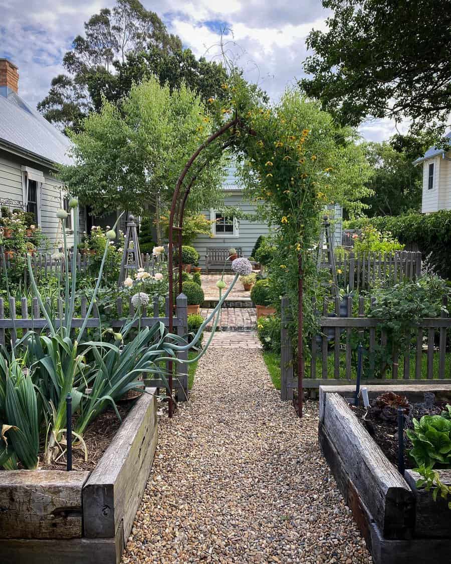 Rustic garden arch with blooming plants and raised beds