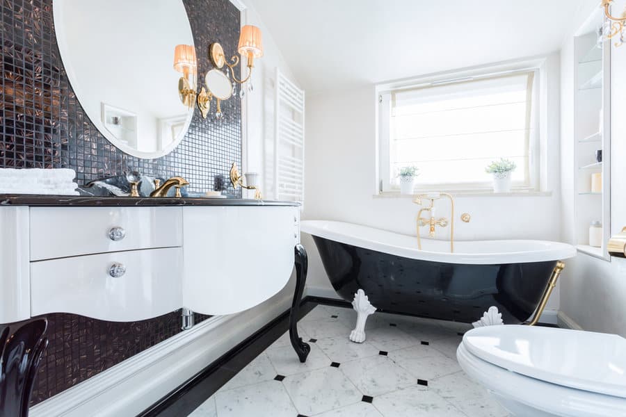 white bathroom with black bath tub and black countertop