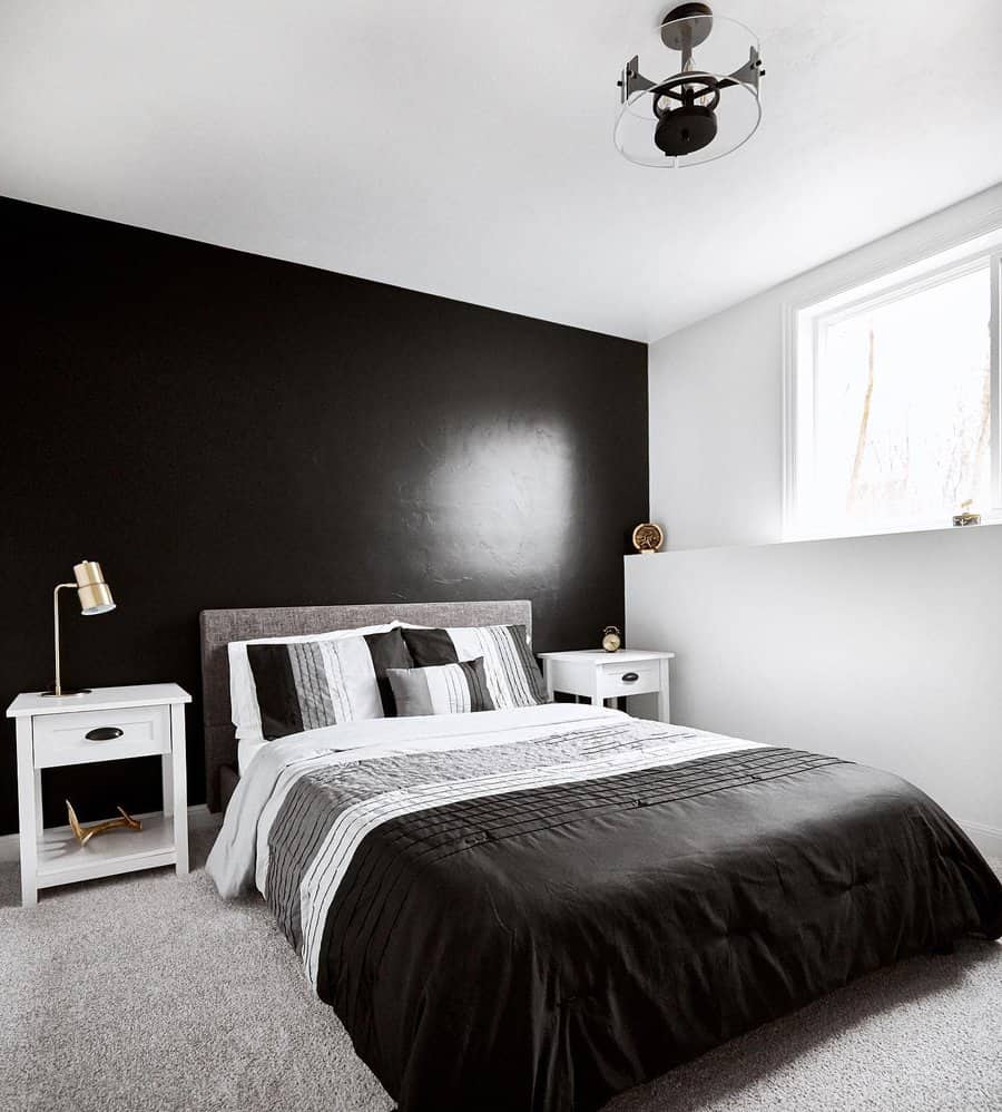 Monochrome bedroom with black accent wall and white bedding