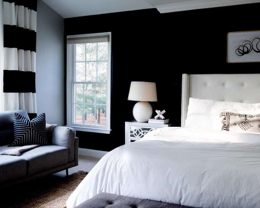 Sophisticated bedroom with black accent wall and striped curtains