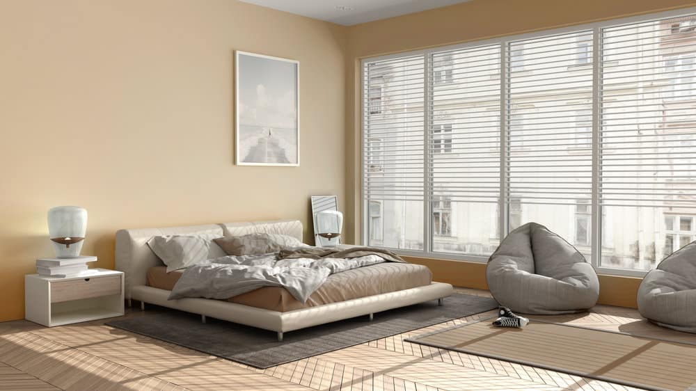 Sunny bedroom with large window and beige decor