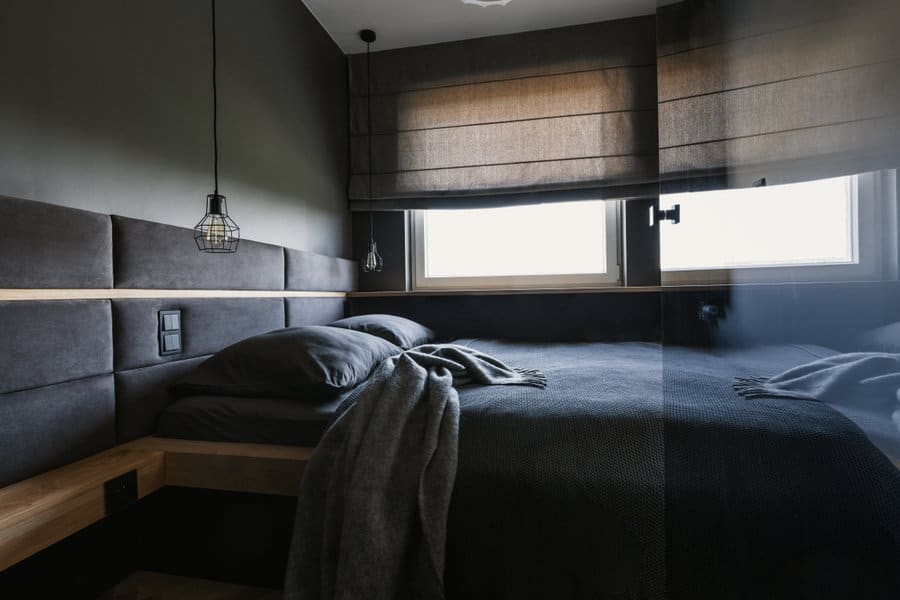 Dark toned bedroom with pendant lights and blinds