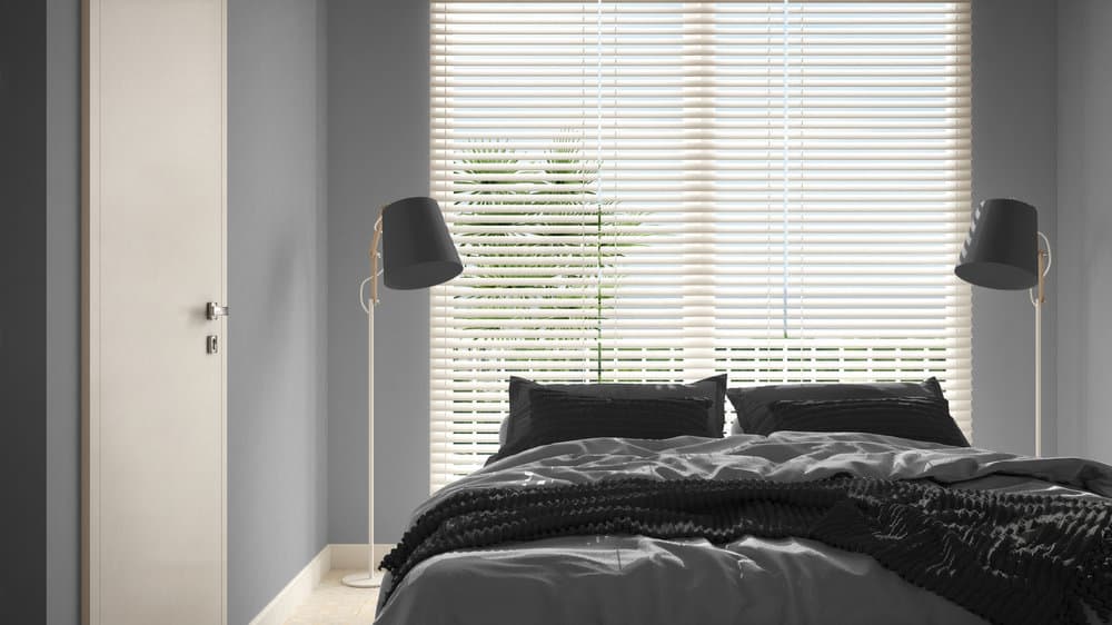 Sleek bedroom with white blinds and wall lamps