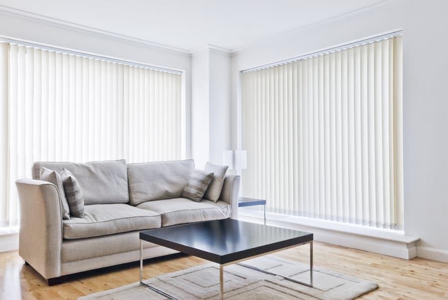 Minimalist living room with a grey sofa and white blinds