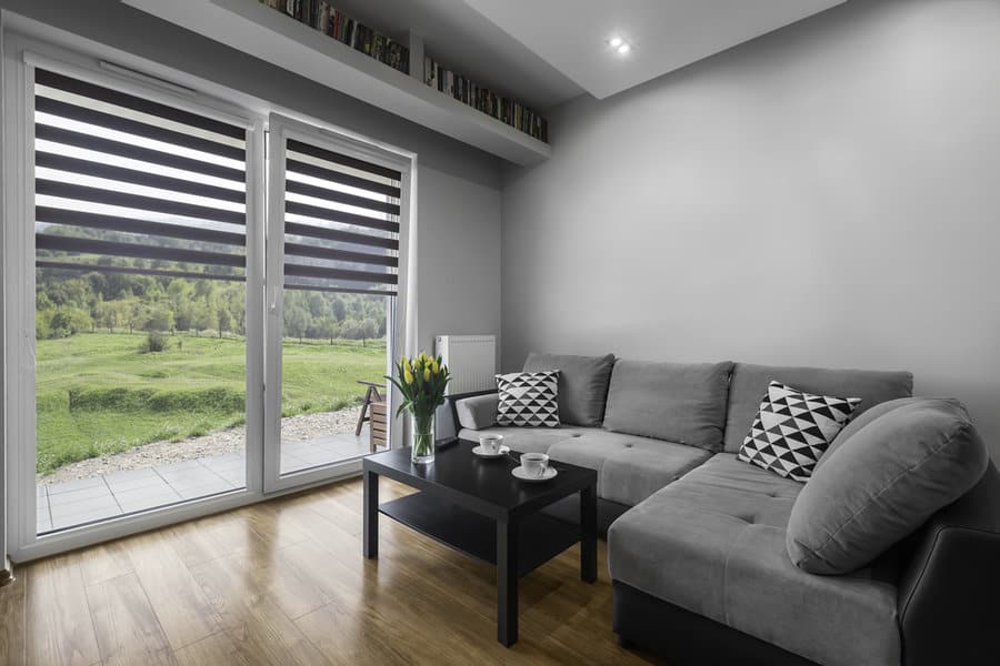 Modern room with zebra blinds and a view of green hills