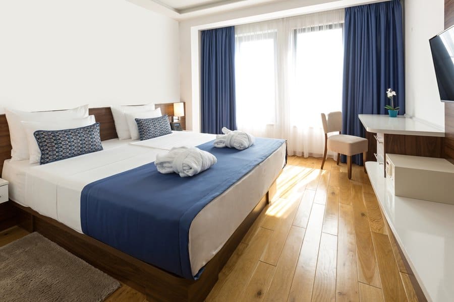 Bright bedroom with blue accents and hardwood floor