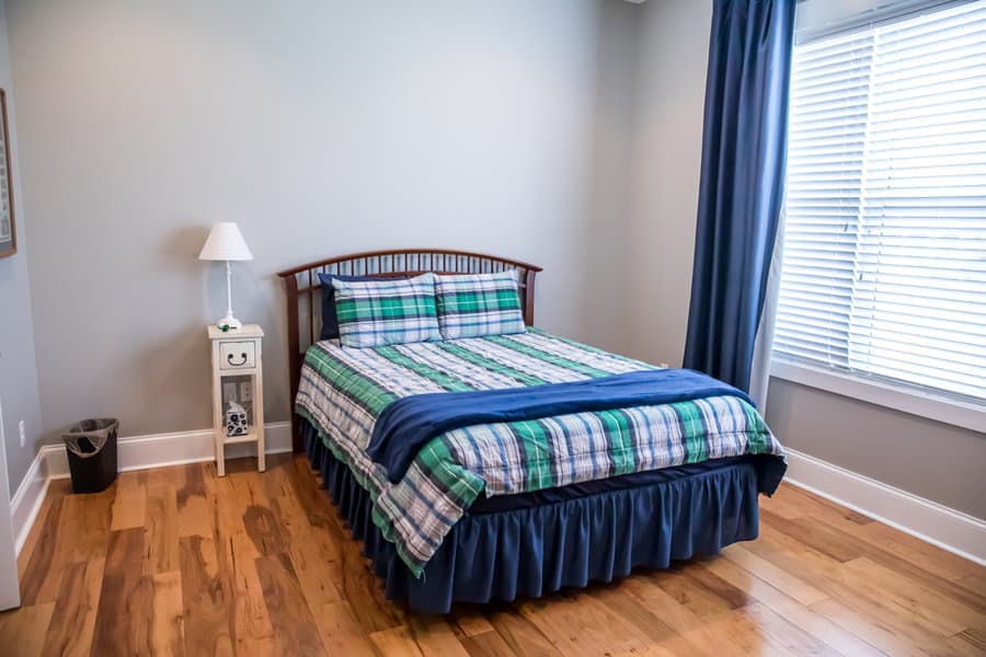 Traditional bedroom with plaid bedding and blue curtains