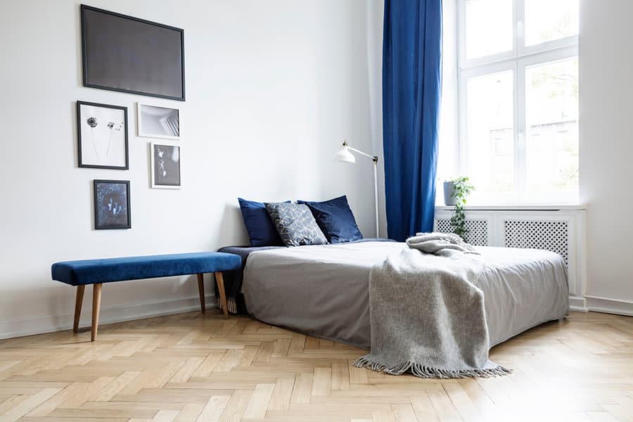 Modern bedroom with blue curtains and art wall