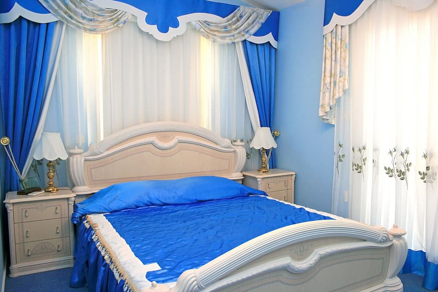 Opulent bedroom with royal blue drapes and sheer curtains