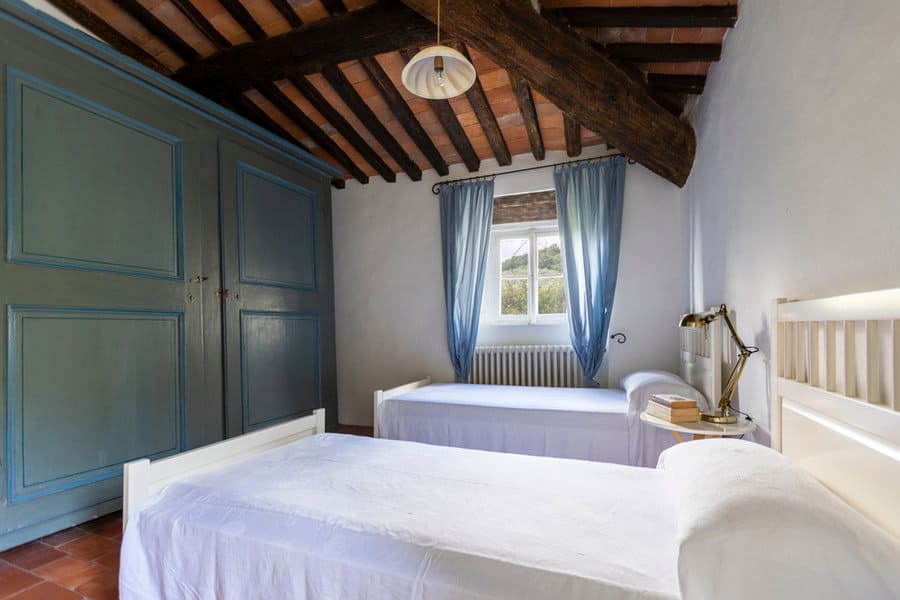 Rustic bedroom with exposed beams and blue curtains