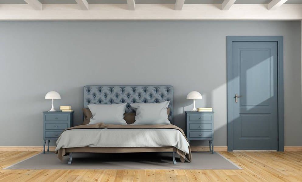 Sophisticated bedroom with blue tufted headboard and grey walls