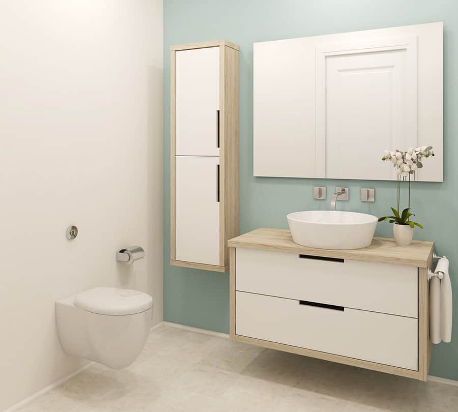 small bathroom with light blue walls and light wood cabinets