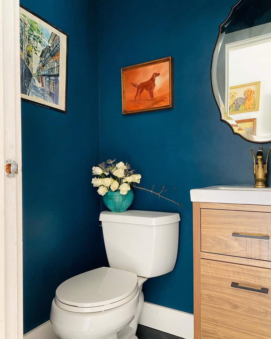 small bathroom with dark blue walls and gold fixtures