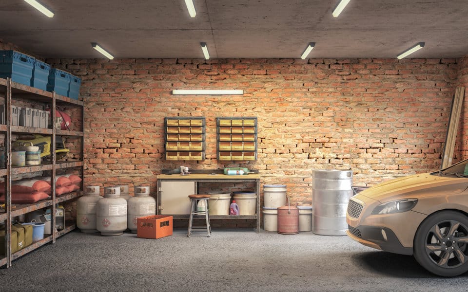 Organized garage with car and exposed brick wall