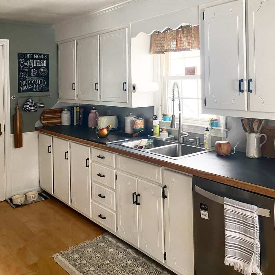 Kitchen with white cabinets and a black countertop