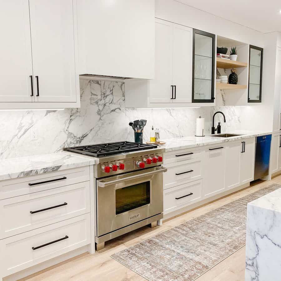 Kitchen boasting white cabinetry and marble countertops