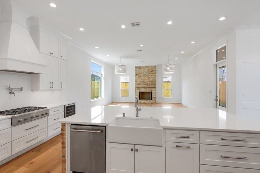 Spacious white kitchen with brick fireplace