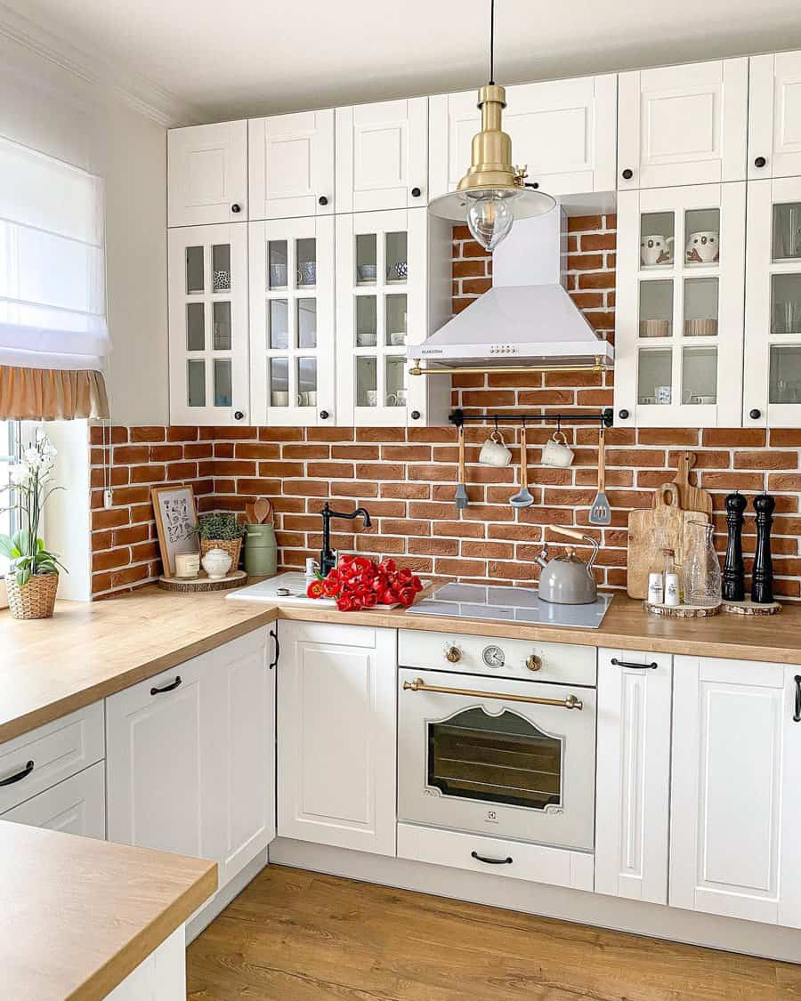 Farmhouse kitchen with brick backsplash and white cabinets