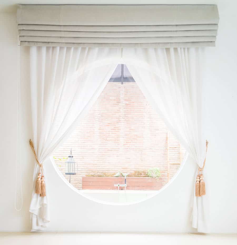 Bright room with sheer curtains and round window