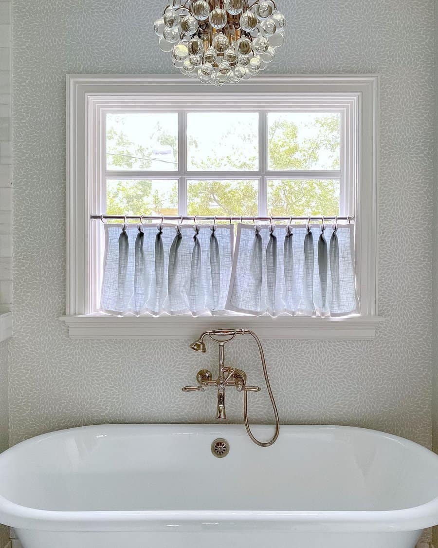 Elegant bathtub with window curtain and chandelier