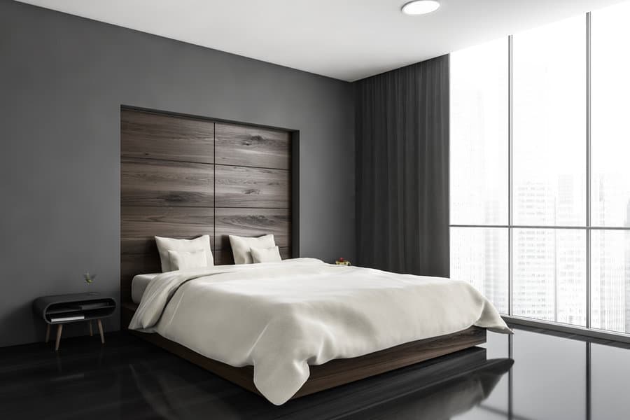 Minimalist bedroom with dark walls and floor to ceiling windows