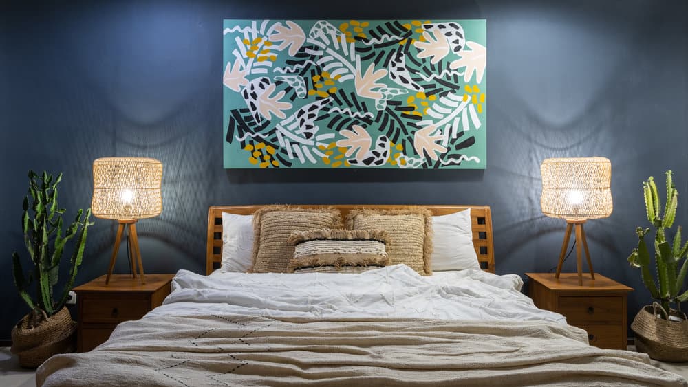 Warm bedroom with navy walls and botanical art