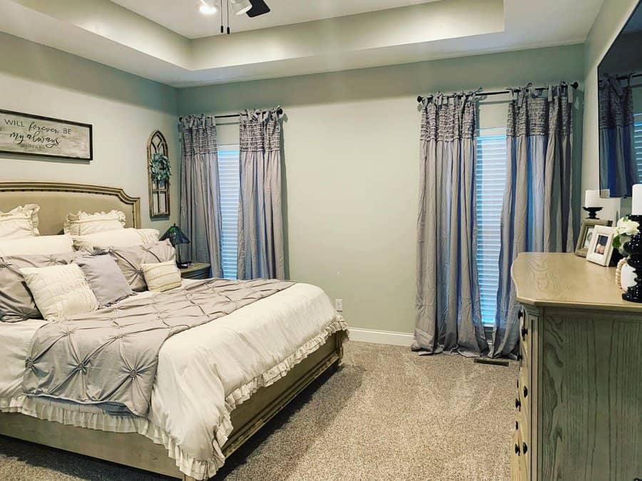 Elegant bedroom with grey curtains and plush bedding