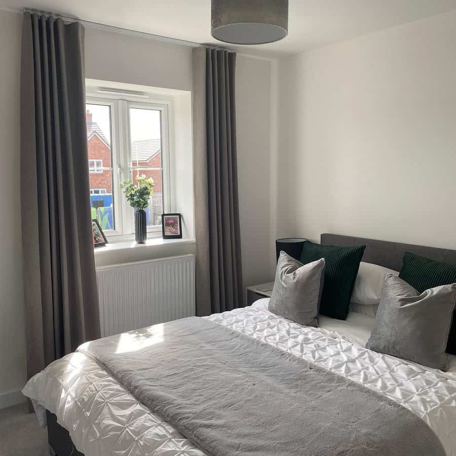 Contemporary bedroom with grey curtains and pendant light