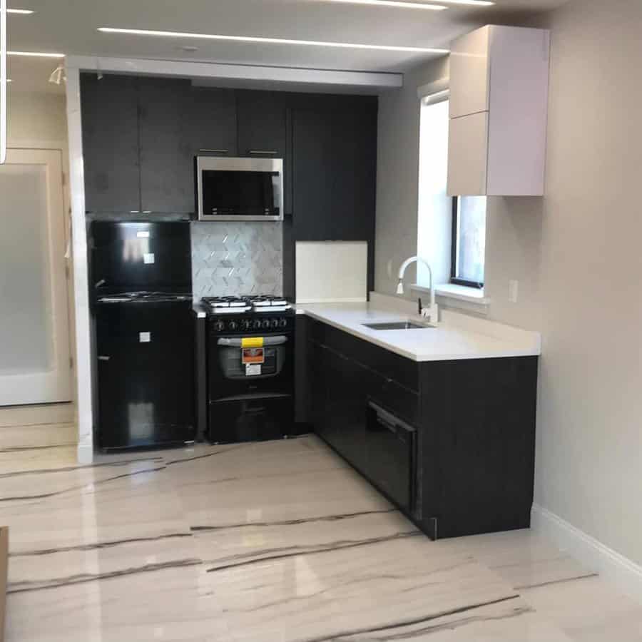 Modern kitchen with dark cabinets and light flooring