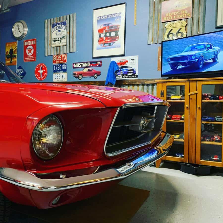 Classic red Mustang in a garage with themed wall decor