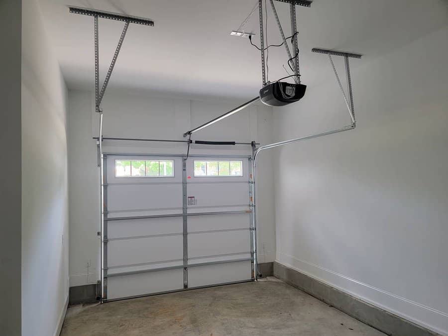 Empty garage interior with closed door and overhead storage