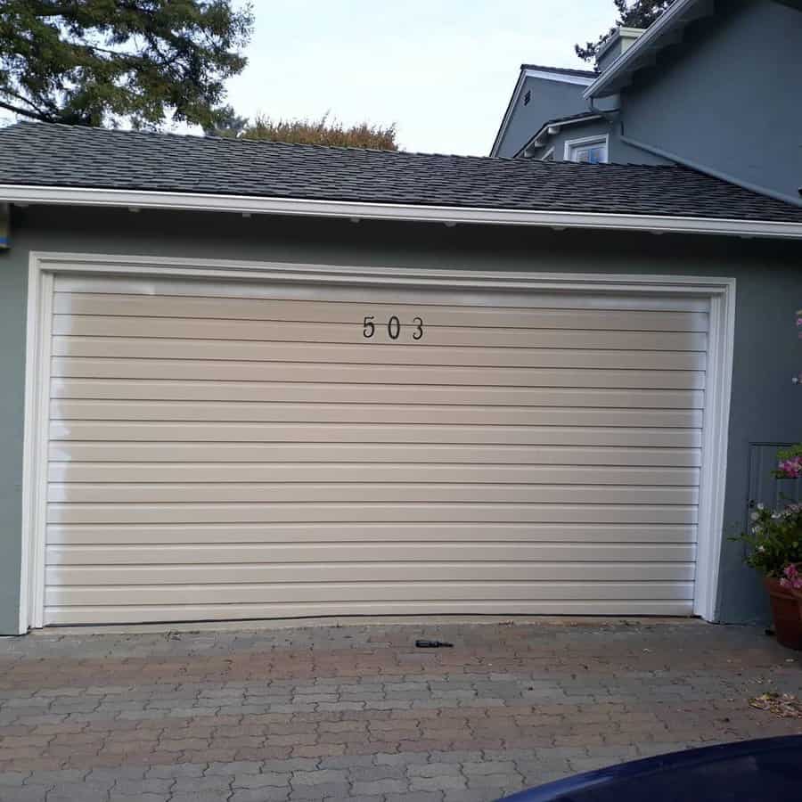 Beige garage door with house number on a residential home