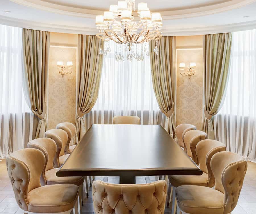 Opulent dining room with golden drapes and chandelier