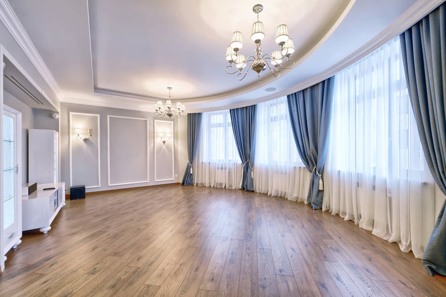 Spacious room with curved blue drapes and chandeliers