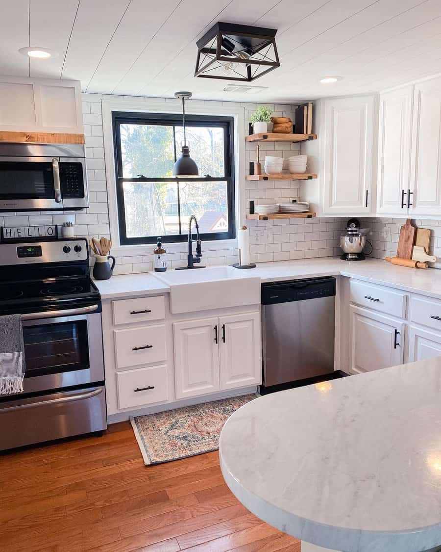 A kitchen with white cabinets and stainless steel appliances