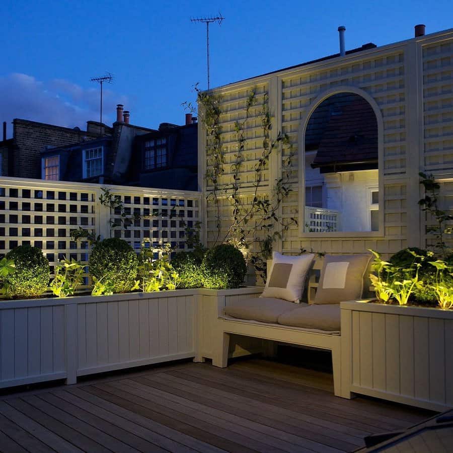 Rooftop garden at dusk with lit trellis and seating