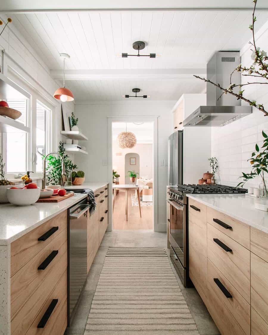 Bright galley kitchen with natural wood cabinets and white walls