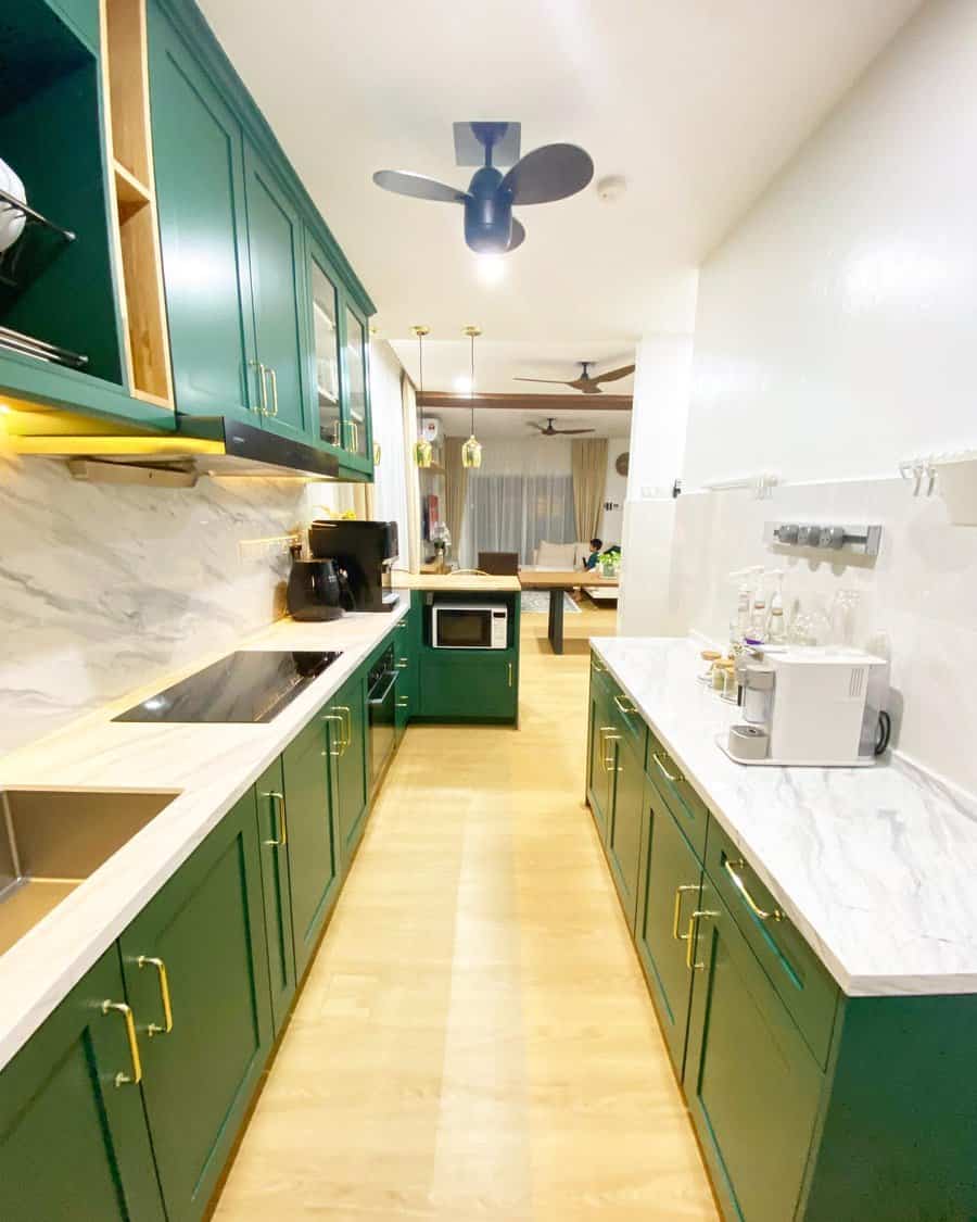 Galley kitchen with green cabinets and marble countertops