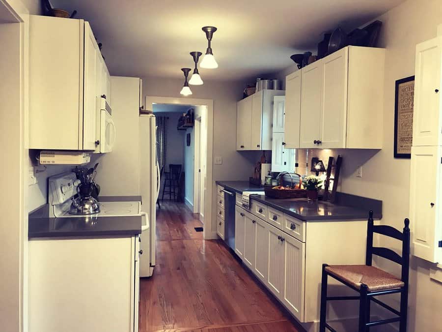 Traditional galley kitchen with white cabinets and wood floors