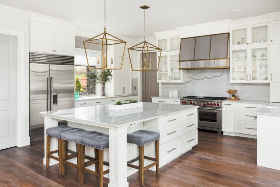 Luxurious white kitchen with brass pendants