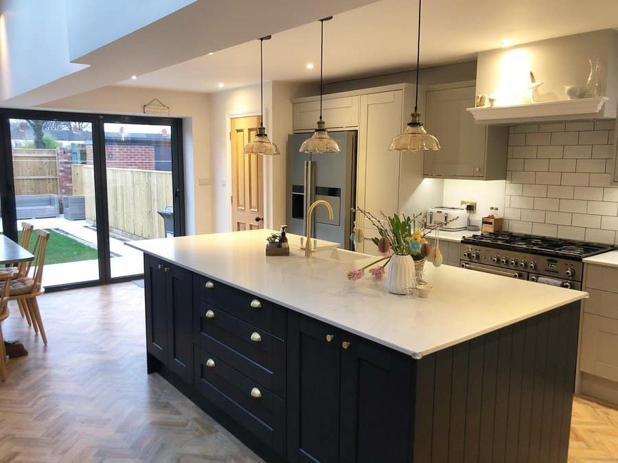 Open kitchen with glass bell pendants and navy island