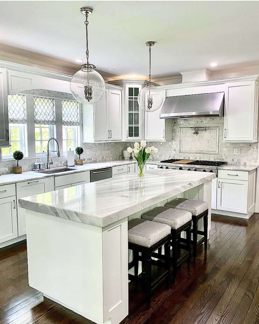 Traditional kitchen with large globe pendants and white cabinetry