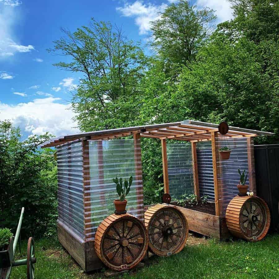 Rustic greenhouse on wheels with corrugated panels and plants