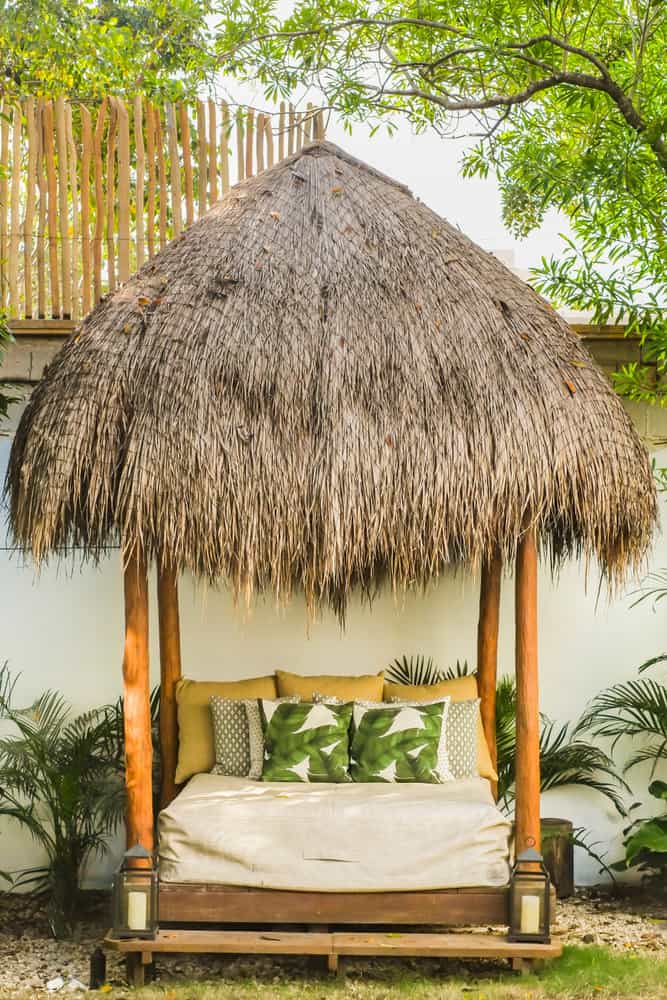 Thatched roof garden cabana with bed