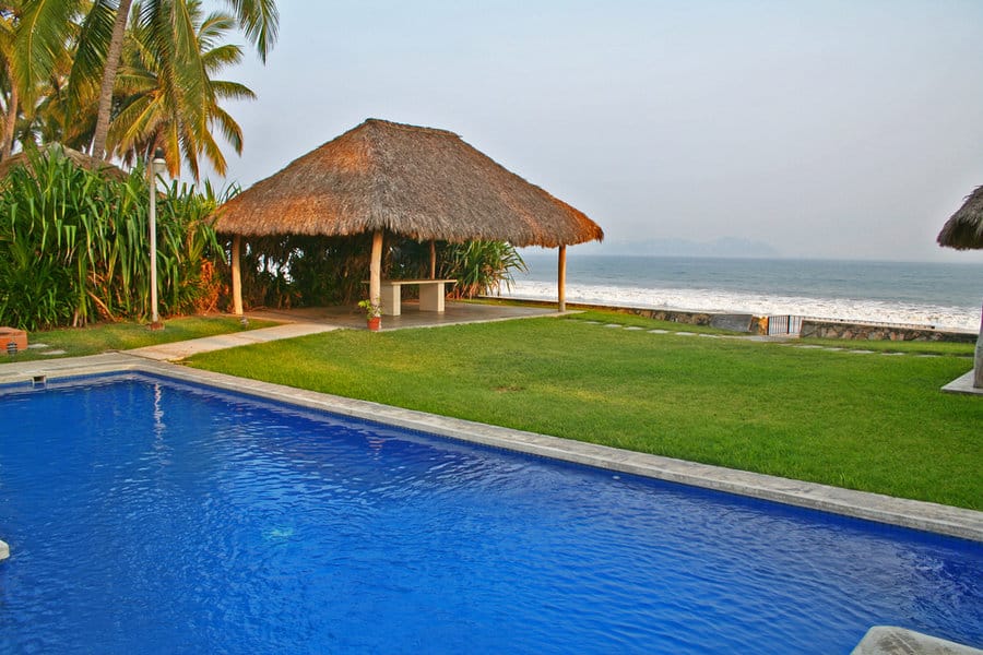 Beachfront pool with palm-thatched hut