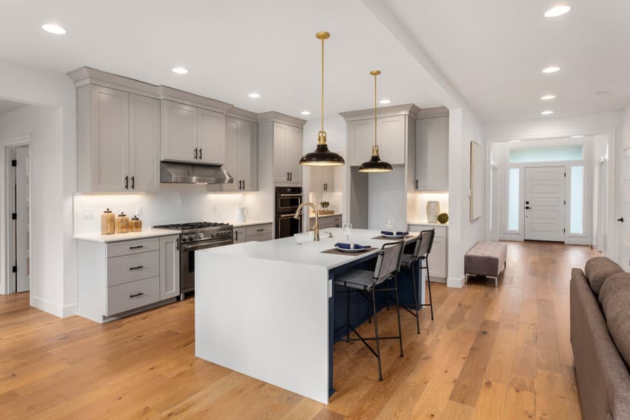 Sleek kitchen with navy details and brass pendants