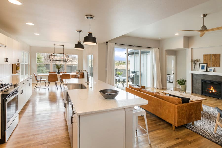 Open concept kitchen with mixed pendant styles and a cozy fireplace