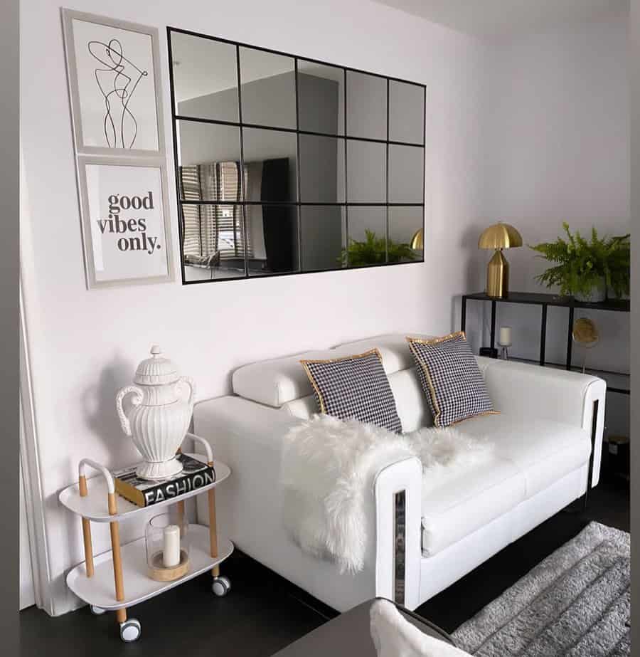 White living room with a mirror and framed quotes