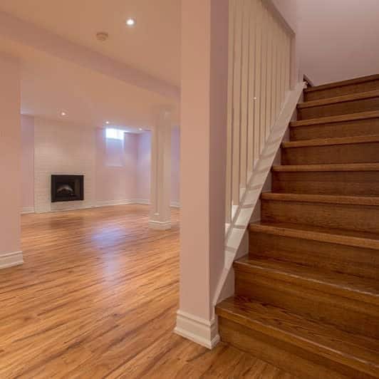 Stairs with hardwood floors and a fireplace