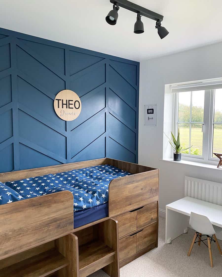 Child's room with blue herringbone accent wall and loft bed